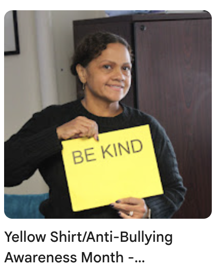 Guidance counselor holding "Be Kind" sign