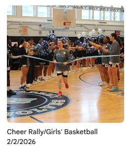 Girls basketball team running through ribbon in gymnasium