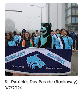 Sammy the seawolf mascot marching with principle Smyth and students holding banner